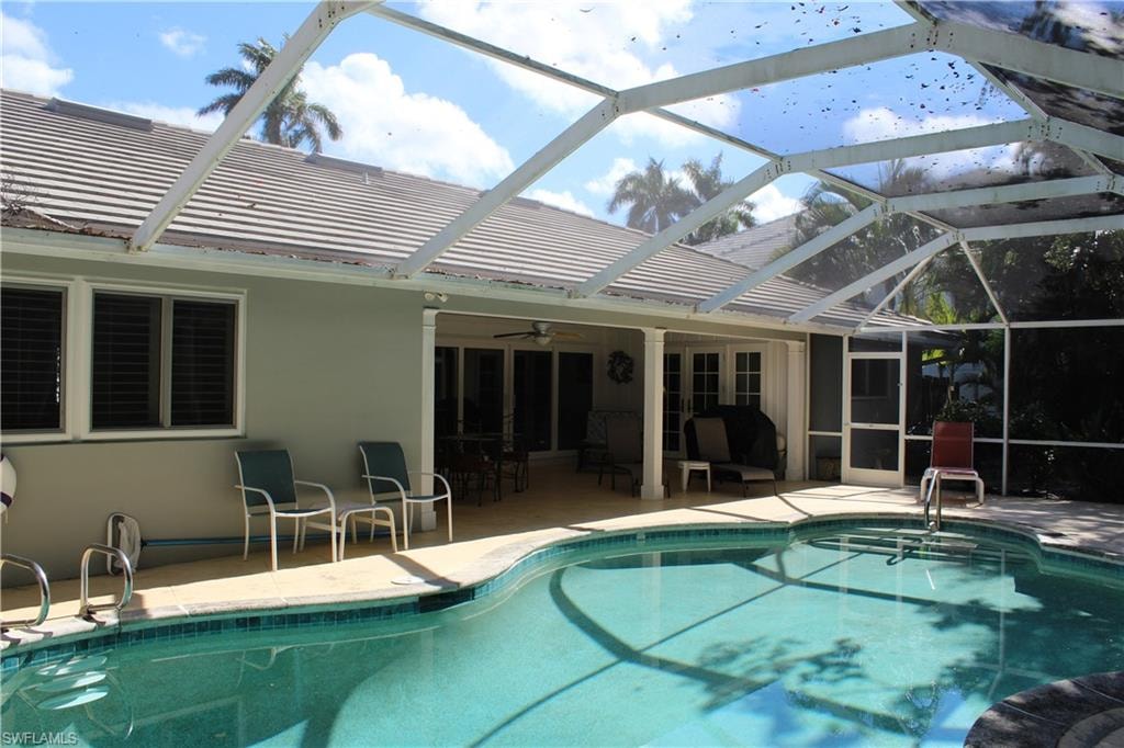 Swimming pool with a patio area, a lanai, a sunroom, and area for grilling