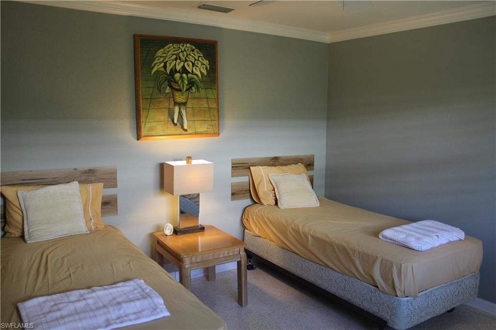 Carpeted bedroom with ornamental molding