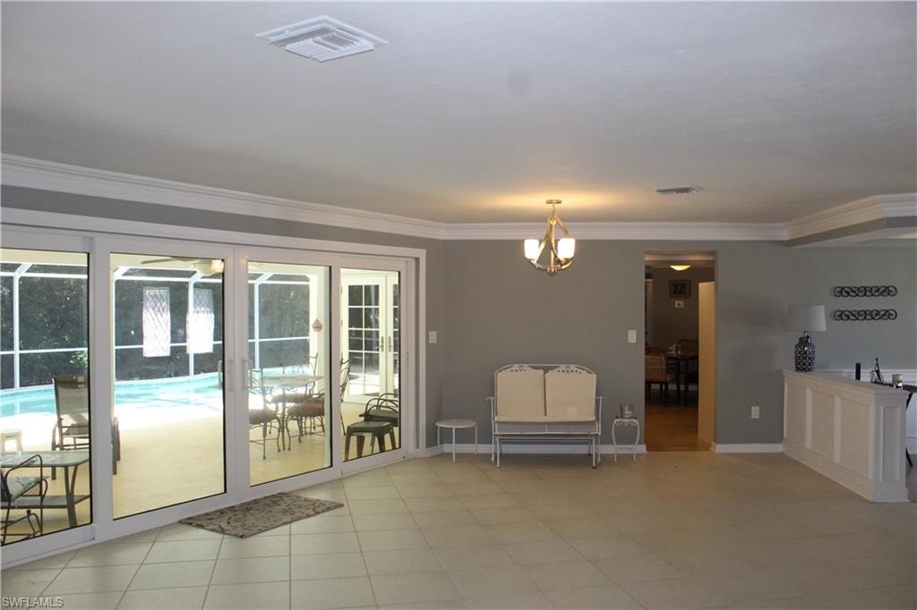 Doorway with crown molding and hanging lights