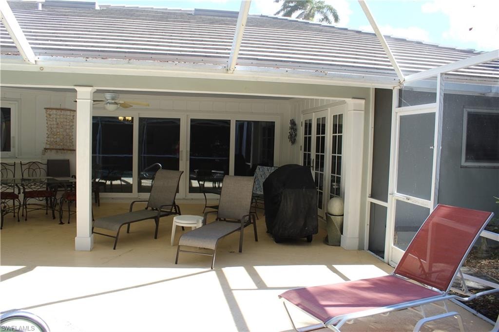 View of patio / terrace featuring outdoor dining space, a grill, and a sunroom