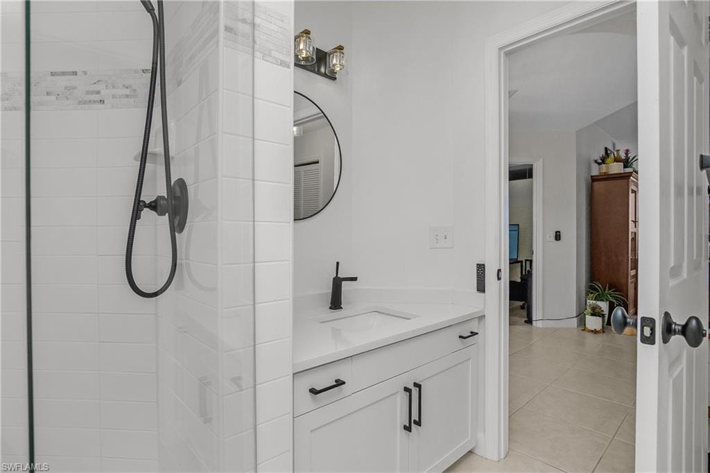 Bathroom with vanity, a stall shower, and light tile patterned flooring