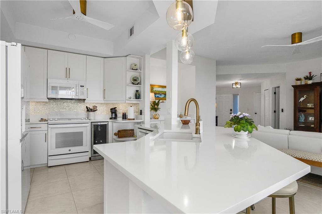 Kitchen featuring ceiling fan, white cabinets, white appliances, and open shelves