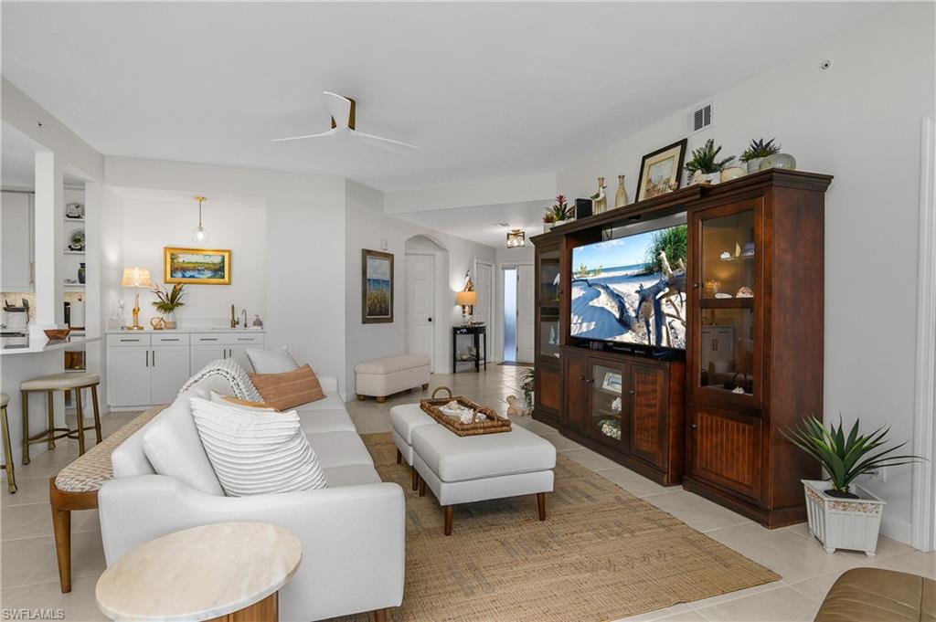 Living area with light tile patterned floors and a ceiling fan
