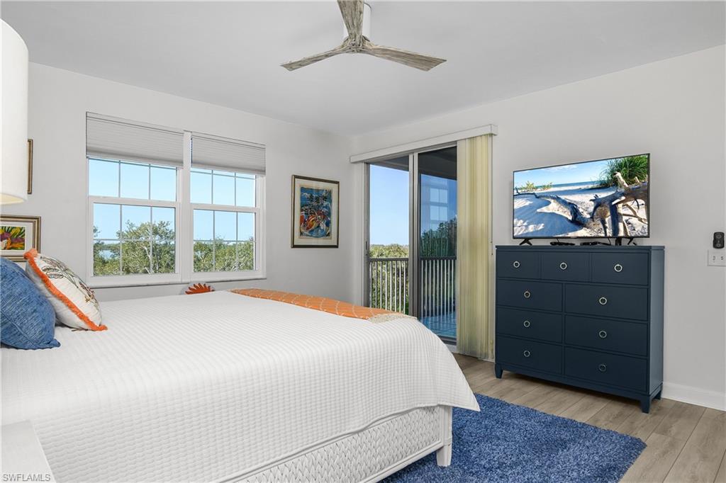 Bedroom with access to exterior, light wood-type flooring, and ceiling fan
