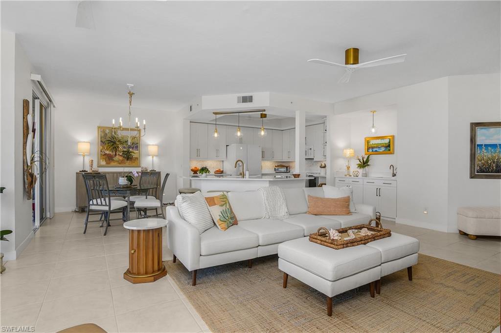 Living area with a ceiling fan, light tile patterned flooring, and suspended lighting