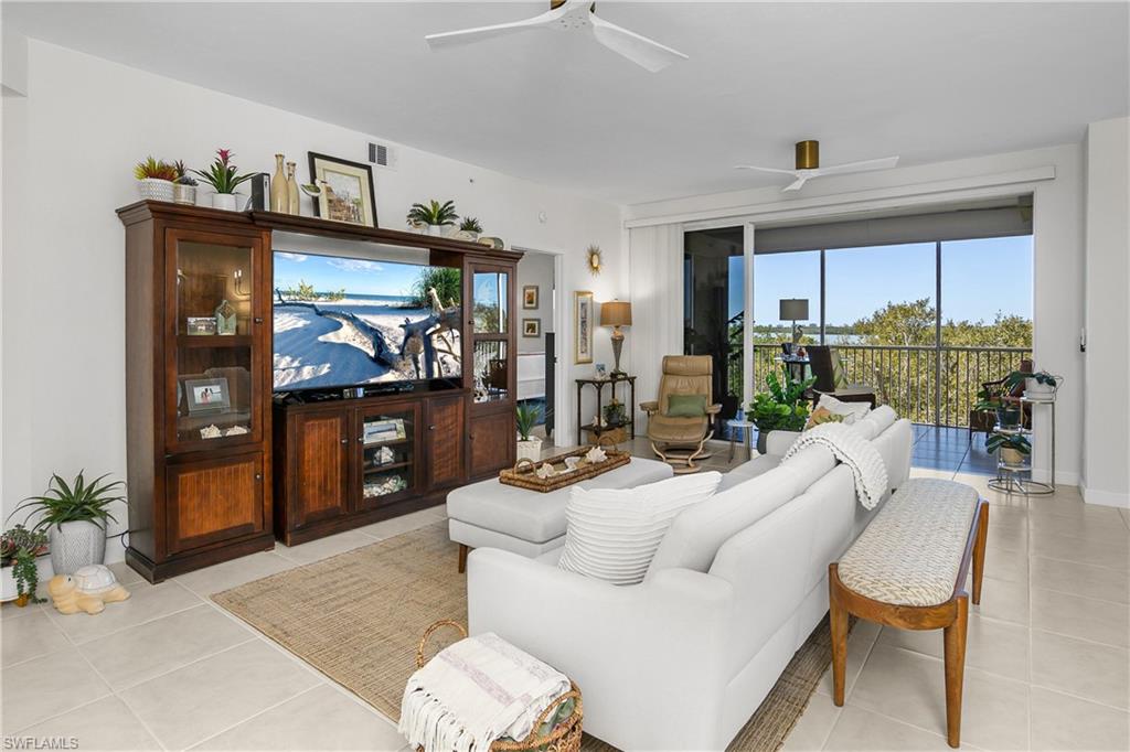 Living room with ceiling fan and light tile patterned floors