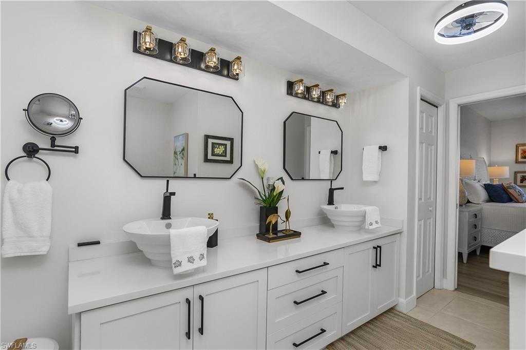 Full bathroom featuring double vanity, ensuite bath, and light tile patterned floors
