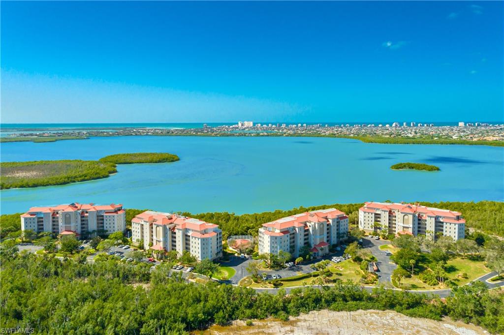Drone / aerial view of apartment complex / building and a nearby body of water