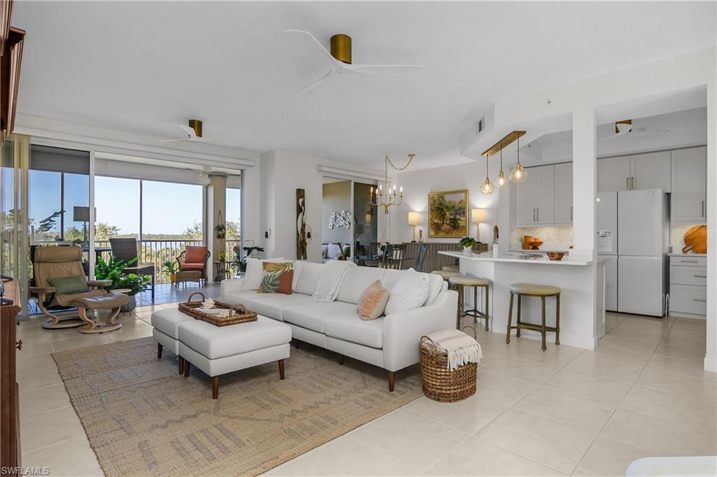 Living area featuring a ceiling fan, hanging lights, and light tile patterned floors