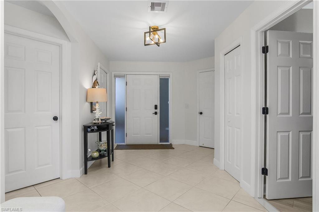 Entryway featuring baseboards and light tile patterned floors