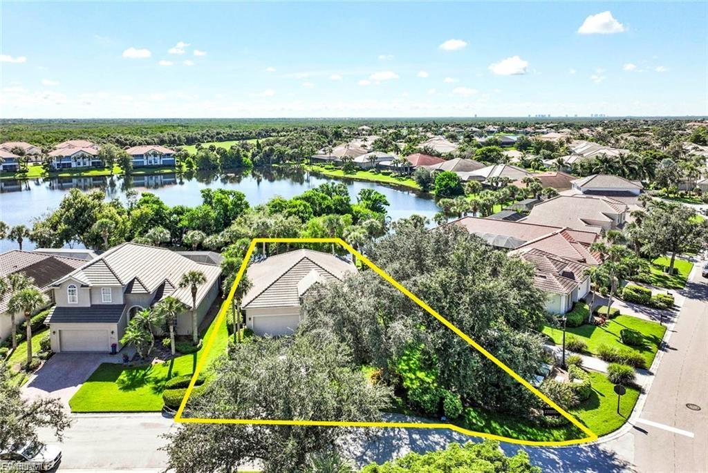 Aerial perspective of suburban area with property boundaries highlighted and a nearby body of water