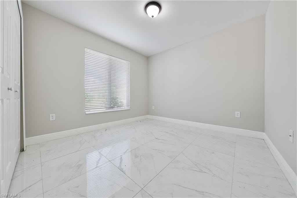 Empty room featuring baseboards and light marble finish flooring