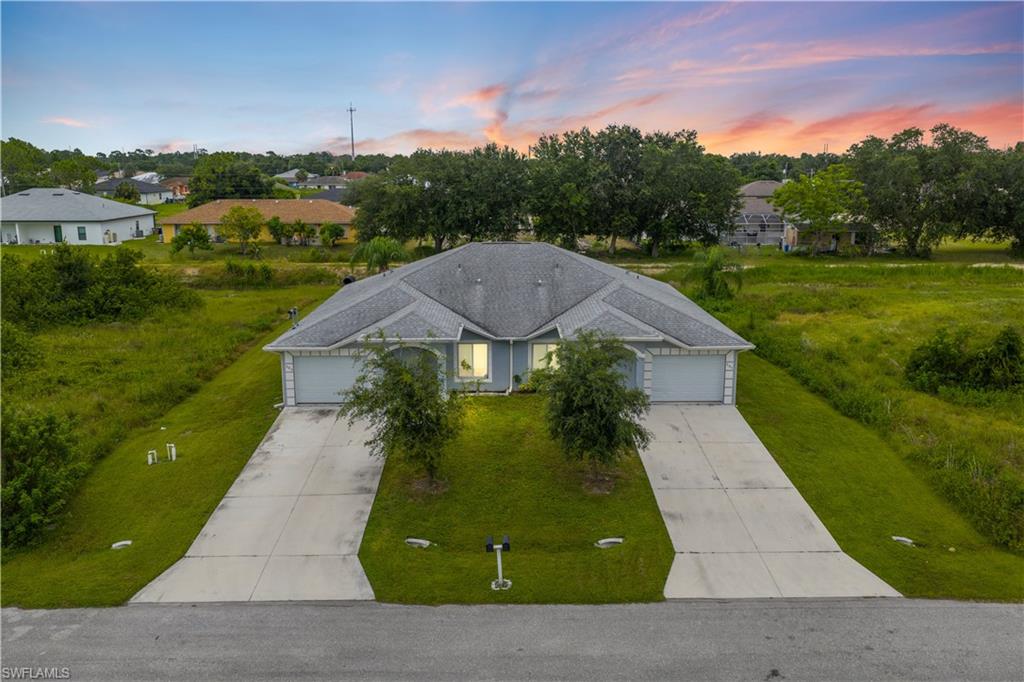 View of front of property featuring a front lawn, a garage, and concrete driveway