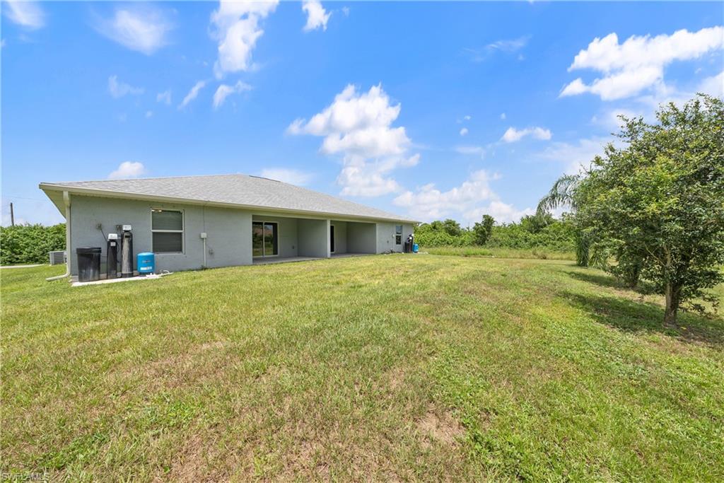 Back of house featuring a lawn and a patio area