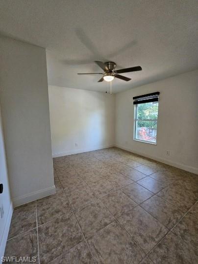 Empty room with tile patterned floors, a textured ceiling, and ceiling fan