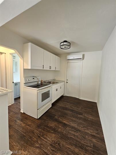 Kitchen featuring white cabinetry, white electric stove, dark wood-style flooring, and light countertops
