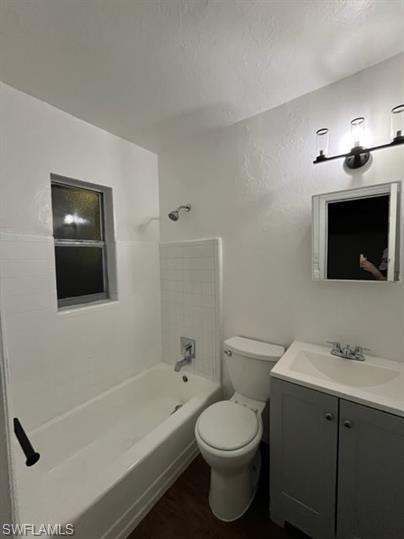 Bathroom with shower / tub combination, vanity, and dark wood-style floors
