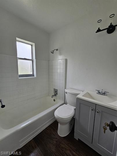 Full bath with vanity, shower / washtub combination, and dark wood-style floors