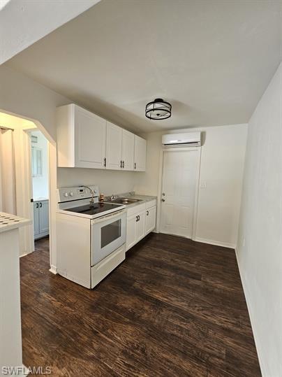 Kitchen featuring white cabinets, white range with electric cooktop, dark wood finished floors, and light countertops