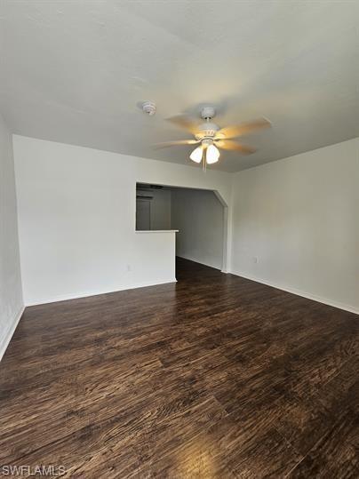 Empty room featuring dark wood finished floors and ceiling fan