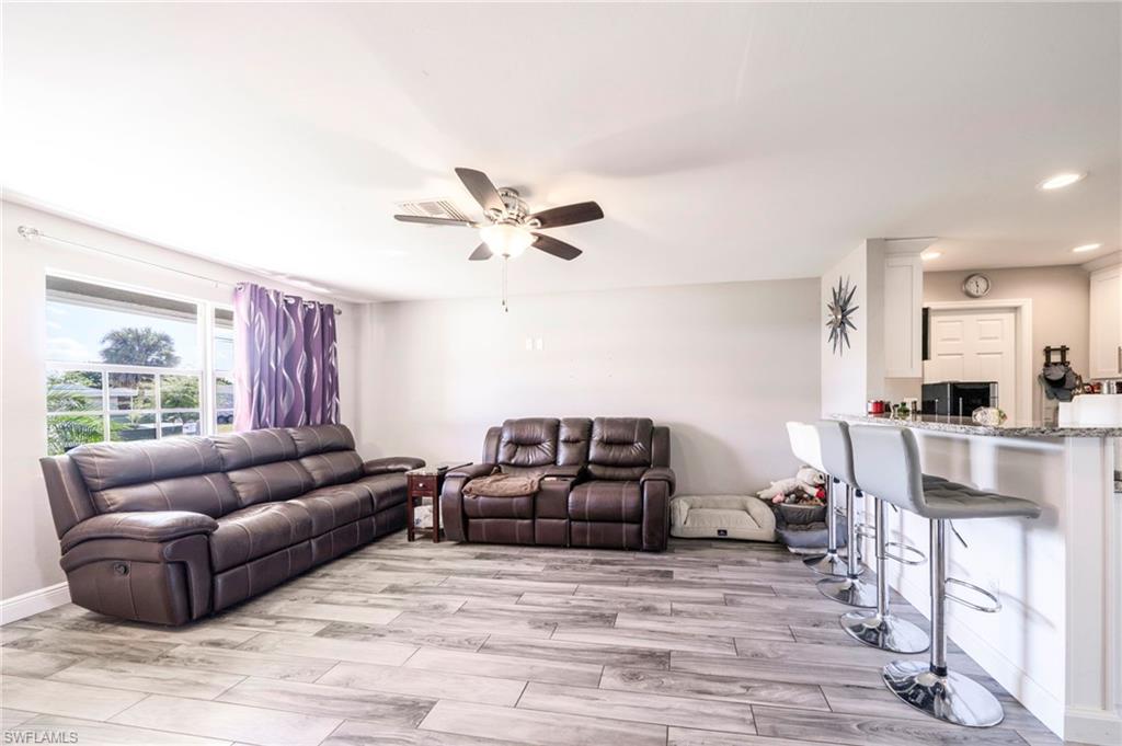 Living room with wood finish floors, ceiling fan, and recessed lighting