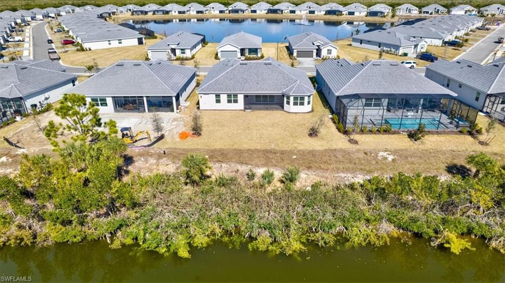 Aerial view of residential area featuring a nearby body of water