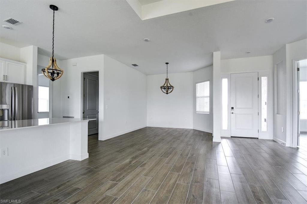 Entrance foyer featuring suspended lighting and wood tiled floors