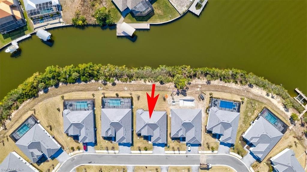 Aerial view of residential area featuring a nearby body of water