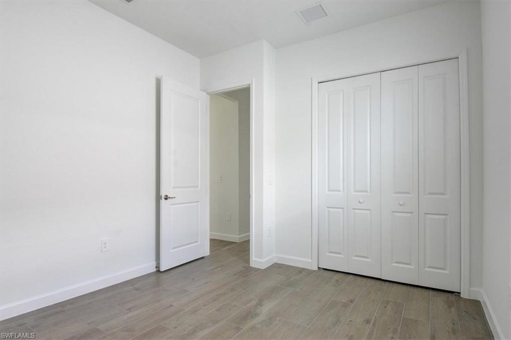 Unfurnished bedroom with light wood finished floors and a closet