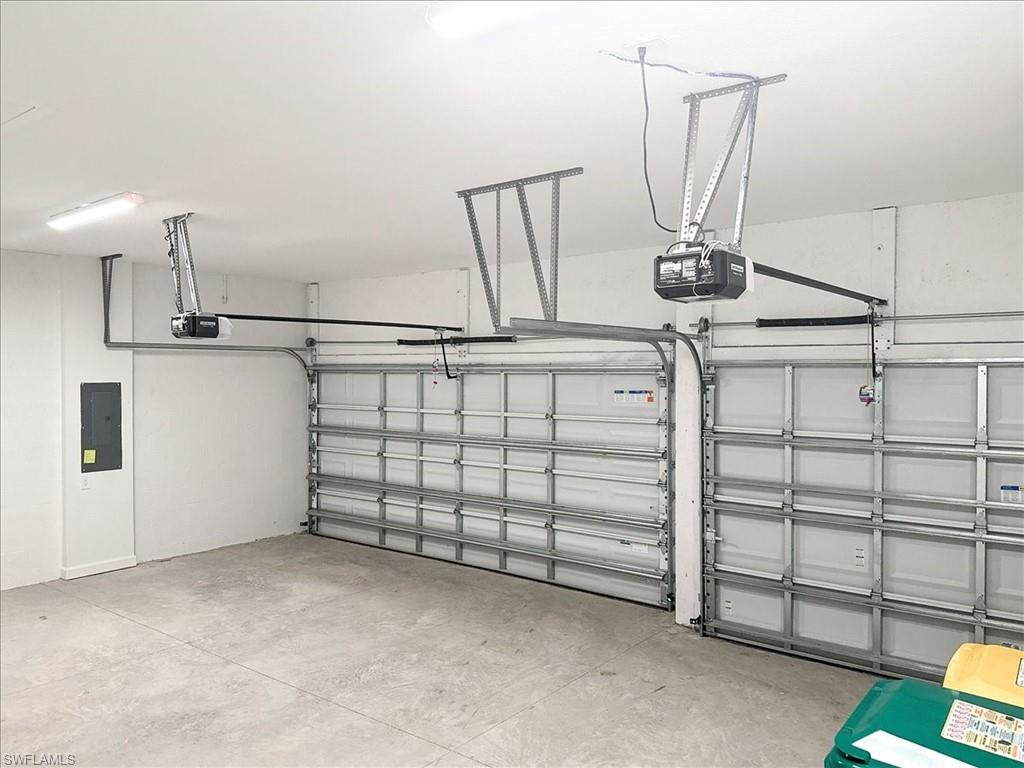 Garage featuring electric panel and a garage door opener