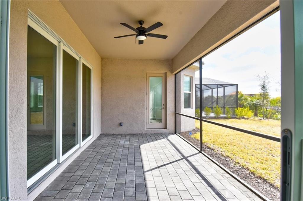 Unfurnished sunroom featuring a ceiling fan and a patio