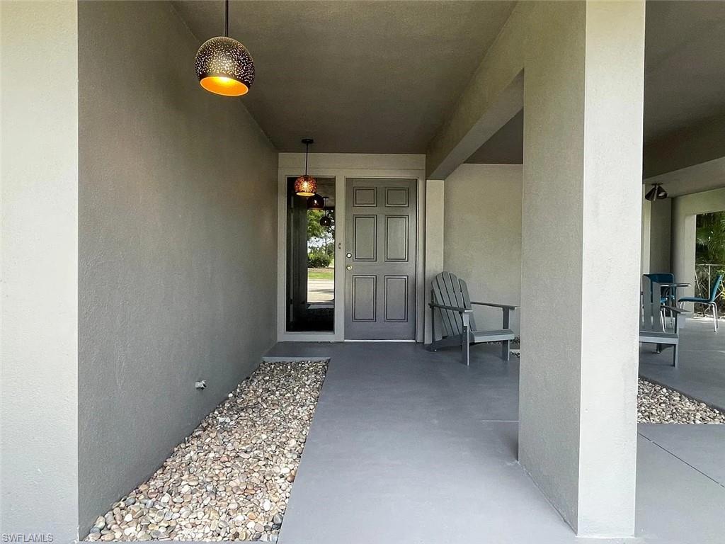 Entrance to property featuring stucco siding and a patio