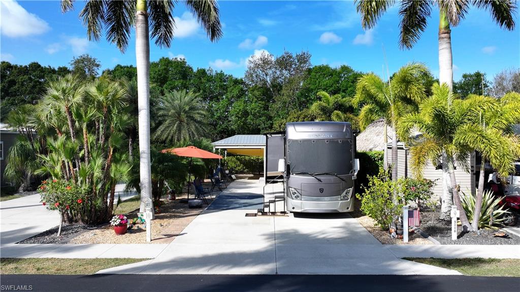 View of parking featuring a carport and concrete driveway