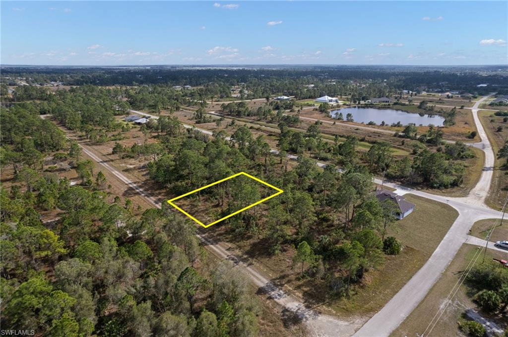 Aerial view of property and surrounding area with property boundaries highlighted and a nearby body of water