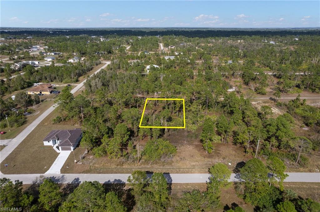 Aerial view of property's location featuring property boundaries highlighted and a heavily wooded area