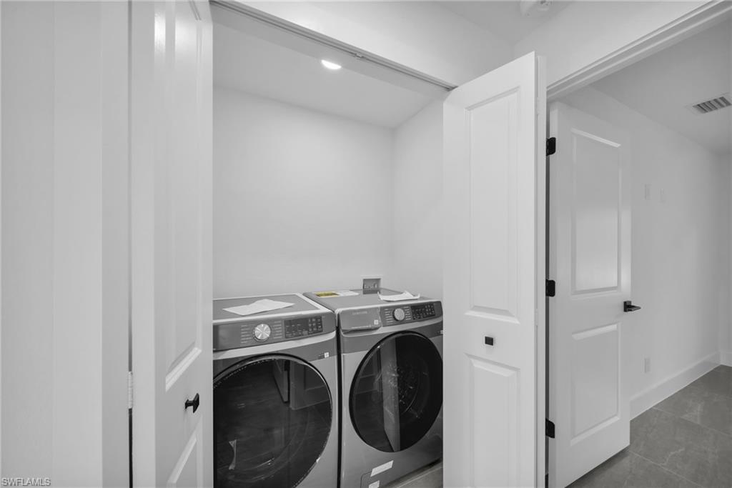 Laundry area with separate washer and dryer and baseboards