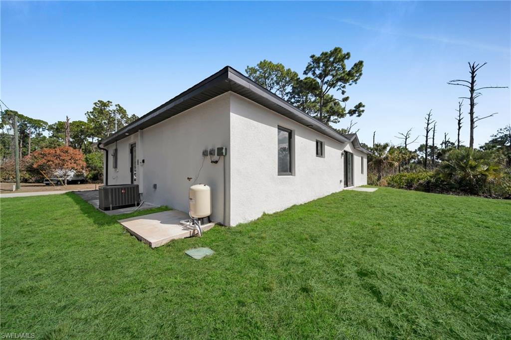 View of home's exterior featuring a lawn and stucco siding