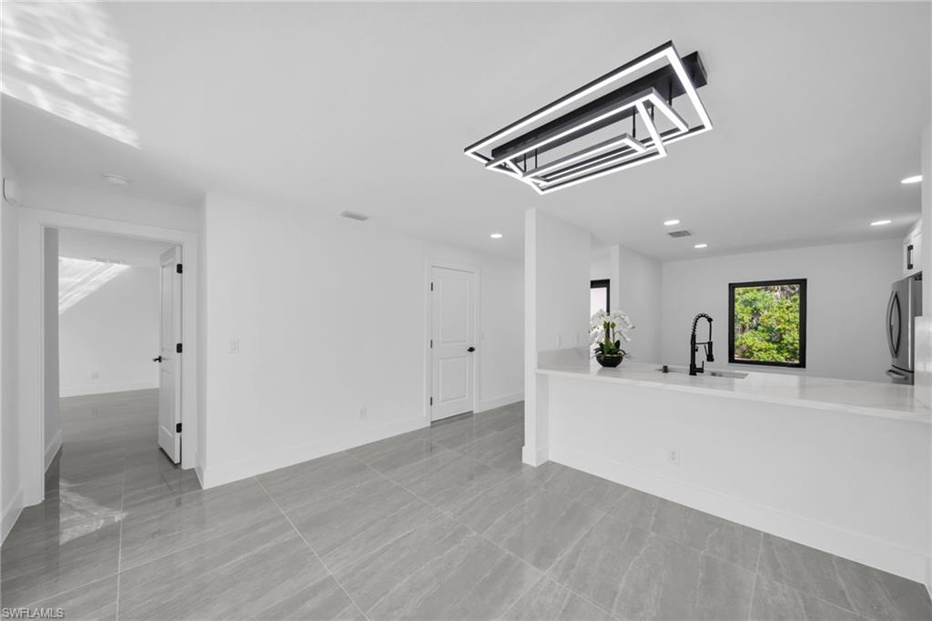 Unfurnished living room featuring a sink and recessed lighting
