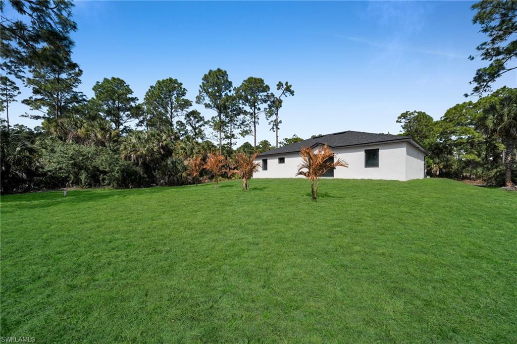 View of grassy yard with view of scattered trees