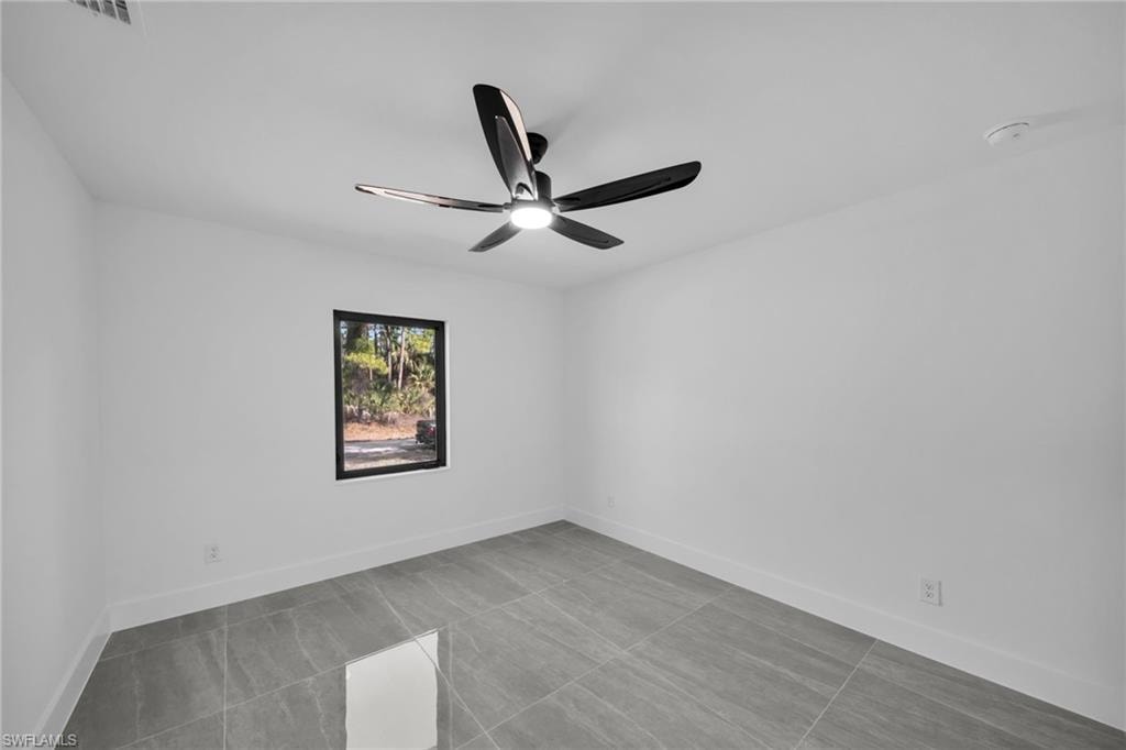 Unfurnished room featuring baseboards and ceiling fan