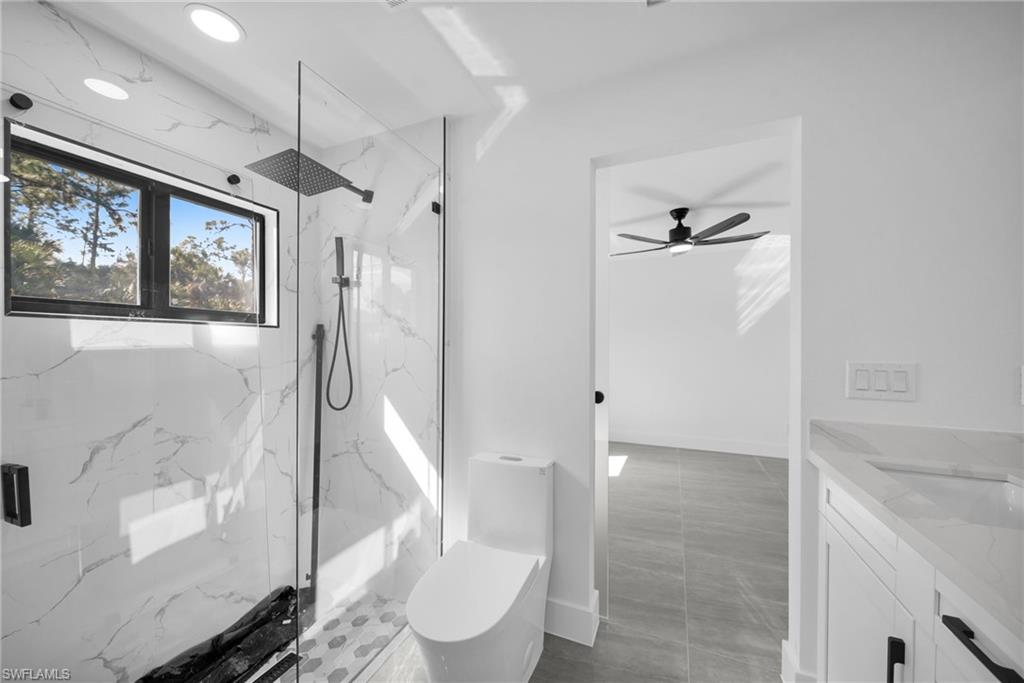 Full bathroom featuring vanity and a marble finish shower