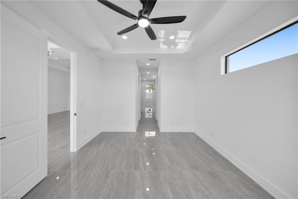 Spare room featuring a tray ceiling, a ceiling fan, and recessed lighting