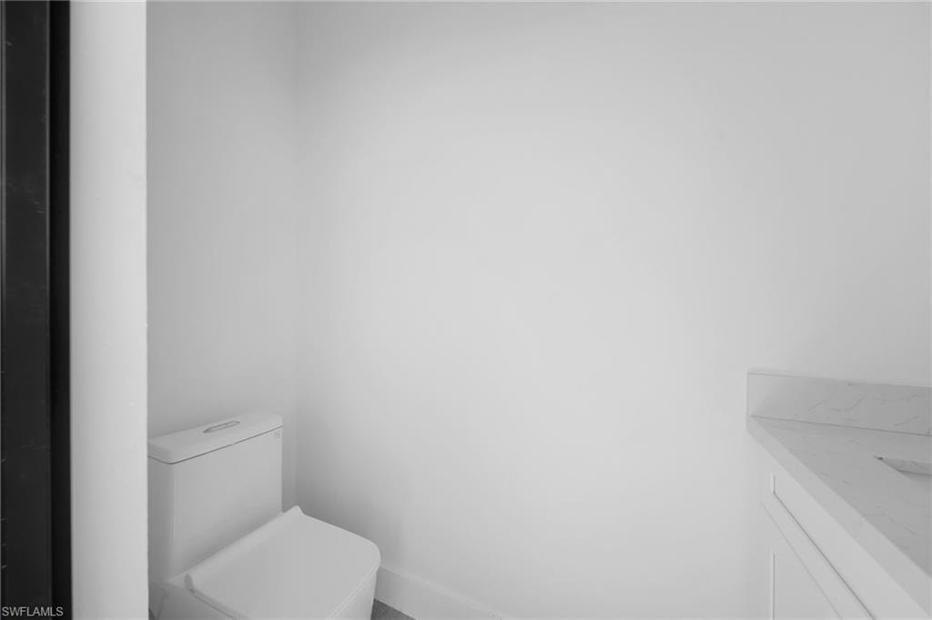 Half bathroom featuring vanity and toilet