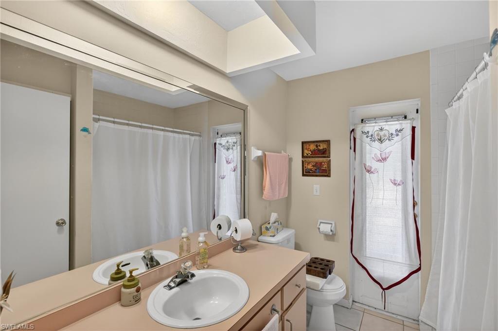 Bathroom with vanity, curtained shower, and light tile patterned floors