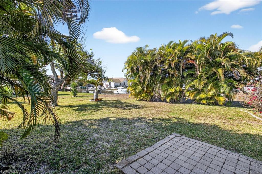 View of grassy yard with a patio area
