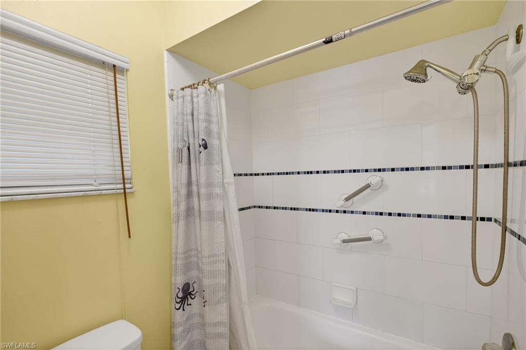 Full bath featuring shower / bathtub combination with curtain and toilet