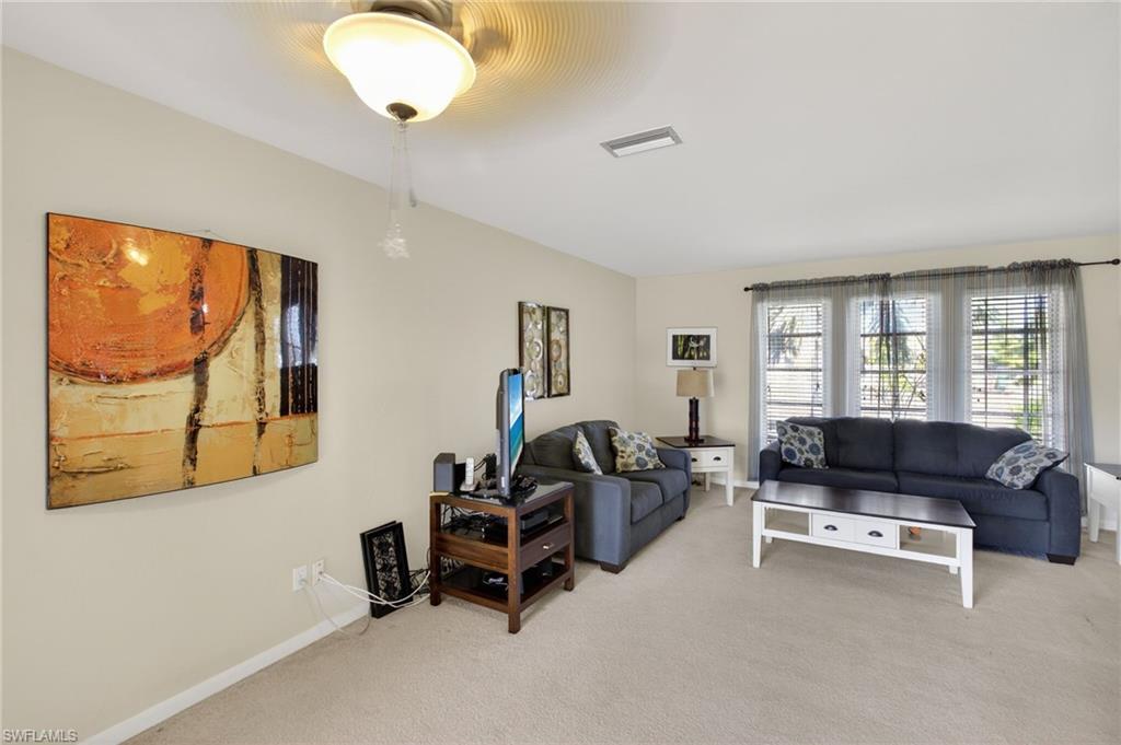 Living area featuring carpet flooring and baseboards