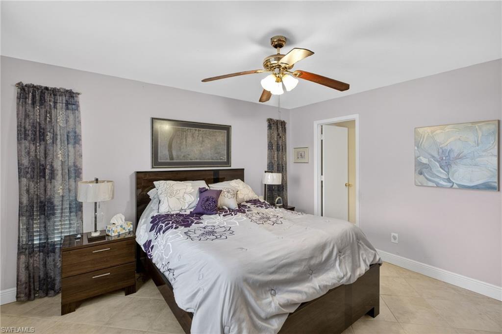 Bedroom with ceiling fan and light tile patterned flooring