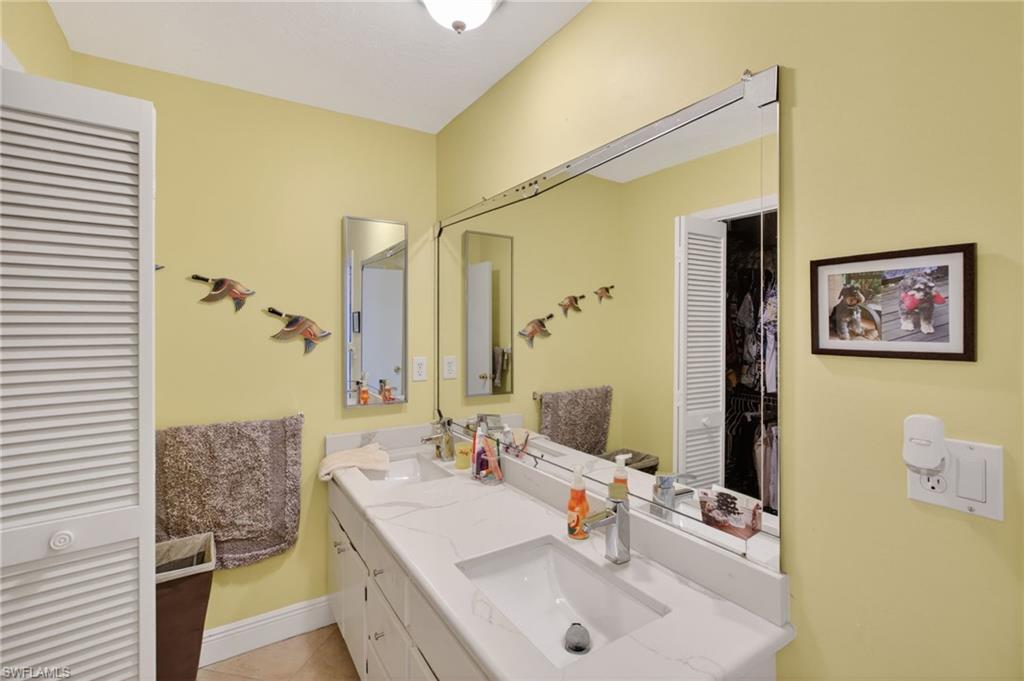 Bathroom with double vanity and light tile patterned floors