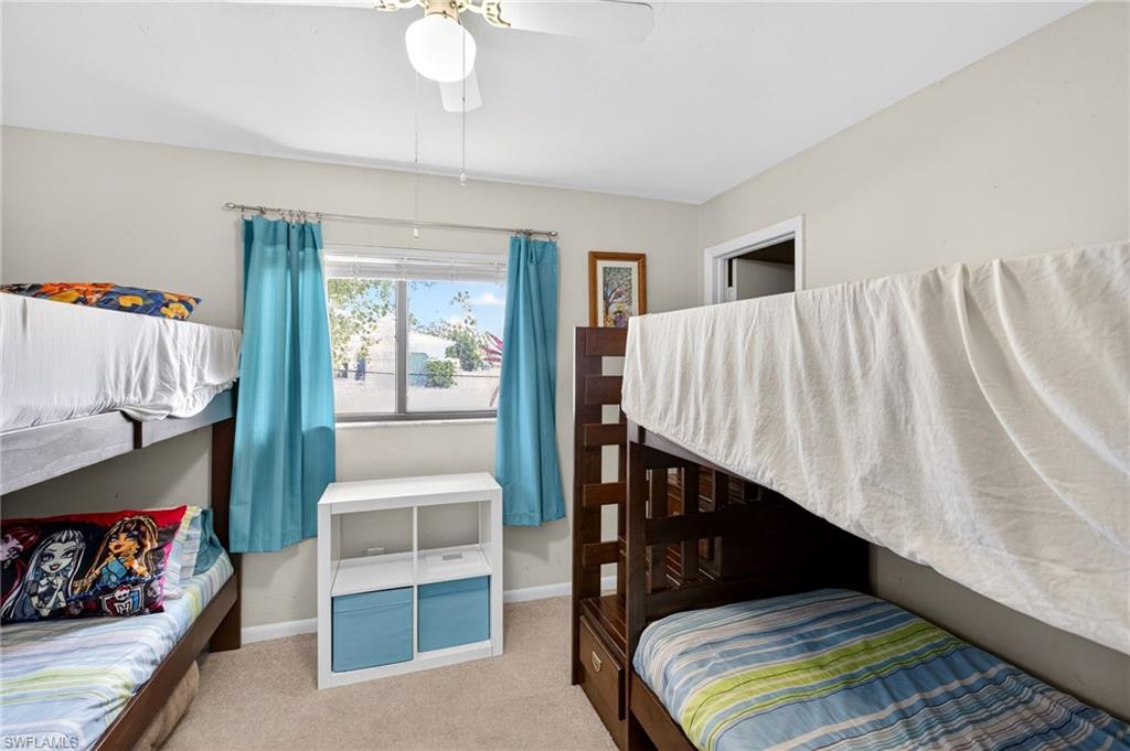 Bedroom with light colored carpet and ceiling fan